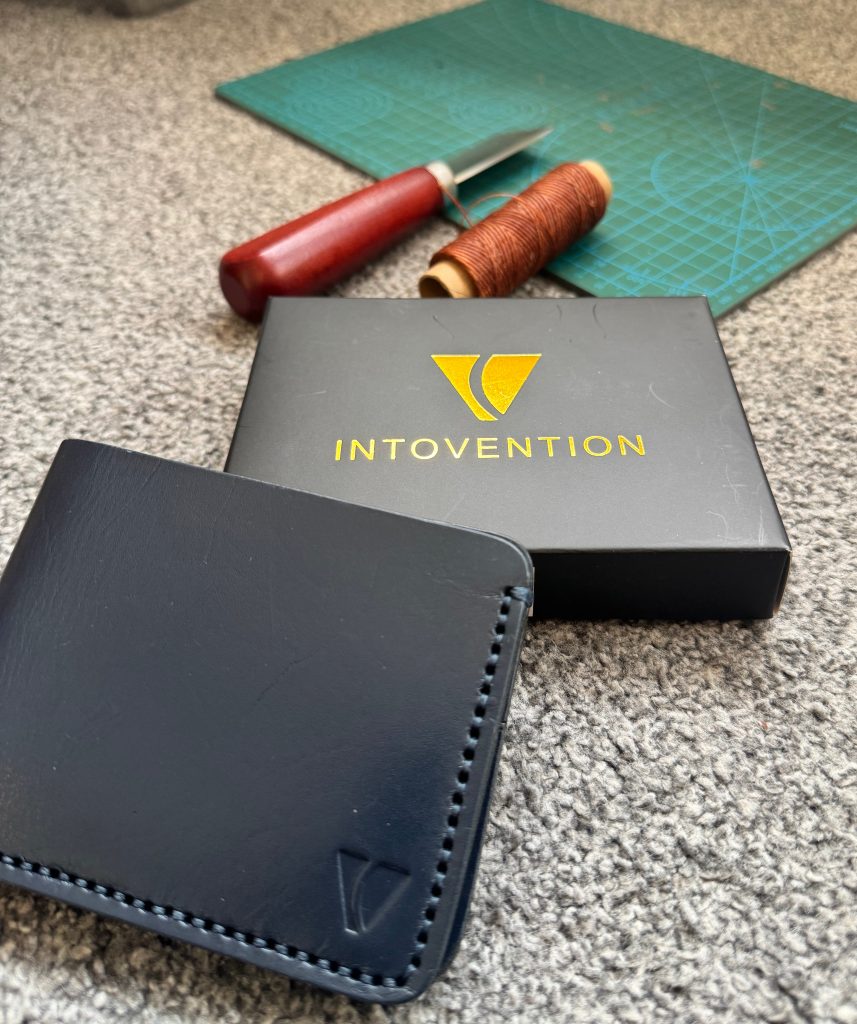Black Intovention leather wallet with branded box and craft tools